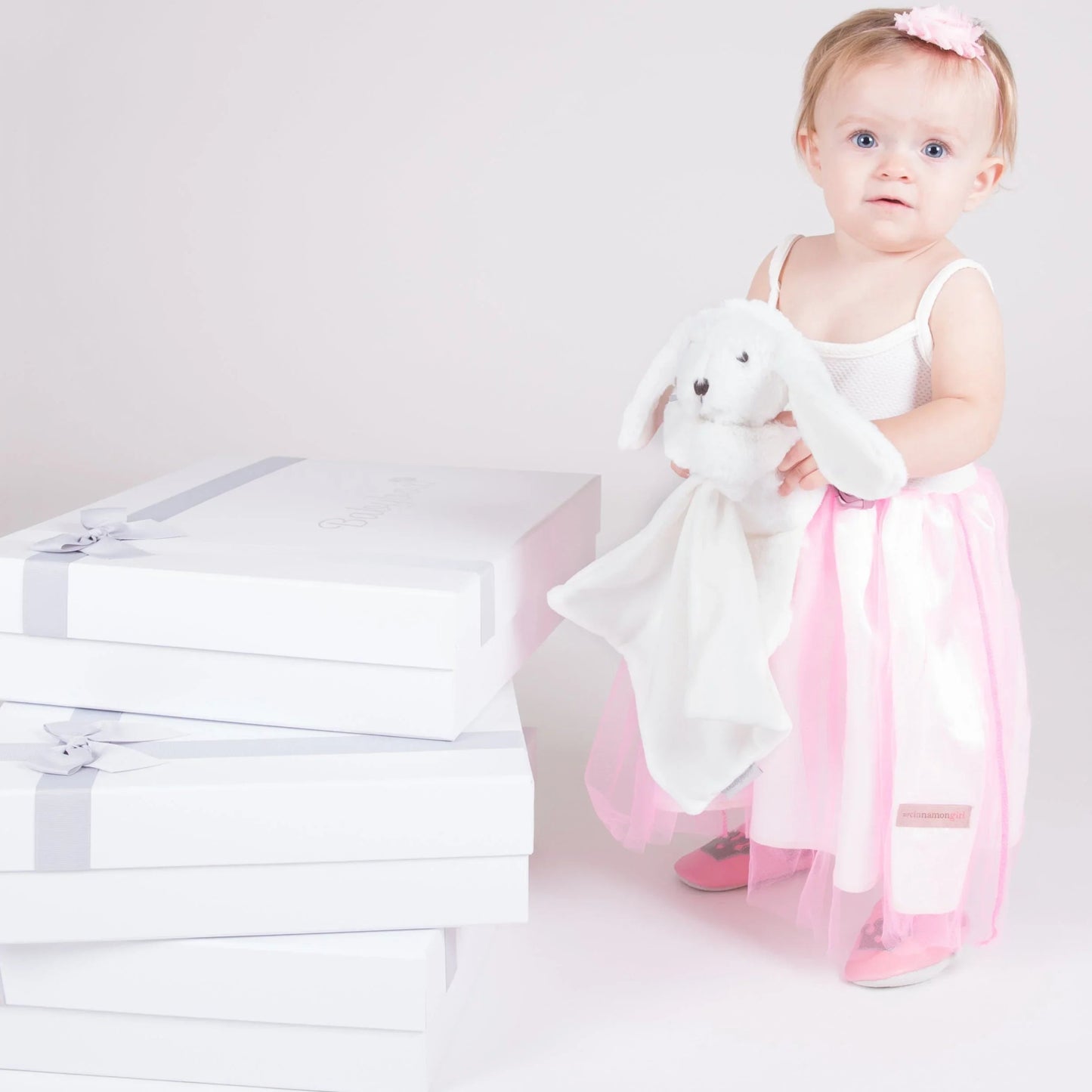 Little girl wearing Little Princess pre-walker baby shoes holding bunnyboo plush toy - Little Babybox