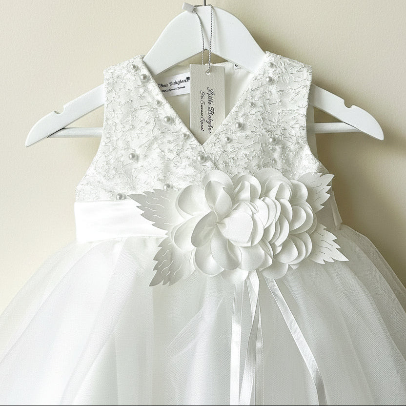 The Amelie Ivory Lace Special Occasion Dress with 3D fabric flower centerpiece hanging from an ornate gold wall hook by Little Babybox.