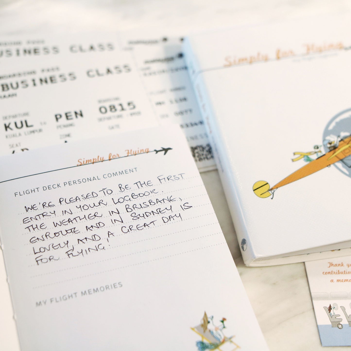 Close up of completed pages in the Simply for Flying Logbook and boarding passes on a light background.