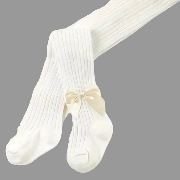 Cream tights for girls with a bow on a light grey background