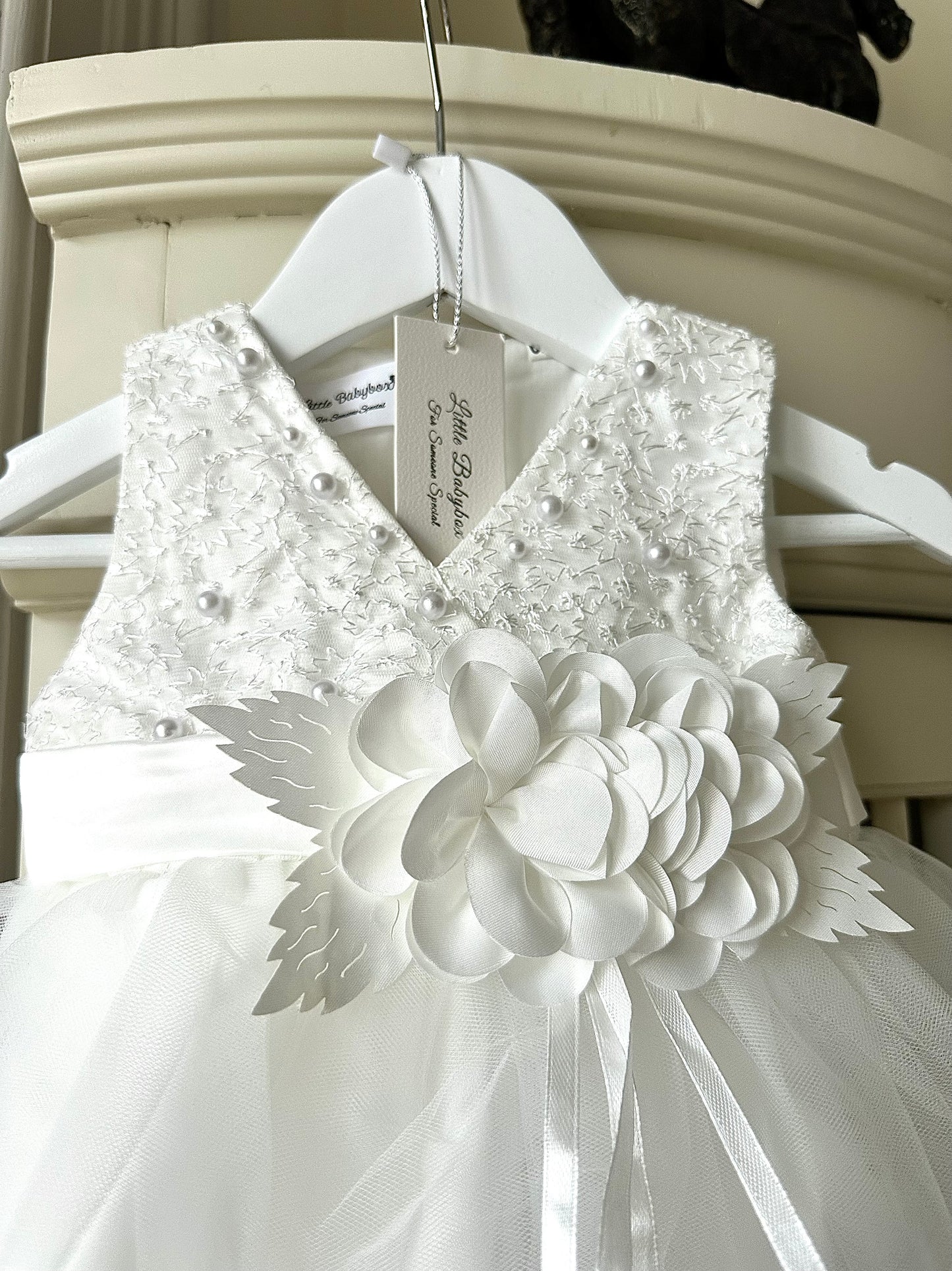 Detailed view of the handmade fabric flower centrepiece and bodice on the ivory white special occasion baby dress by Little Babybox