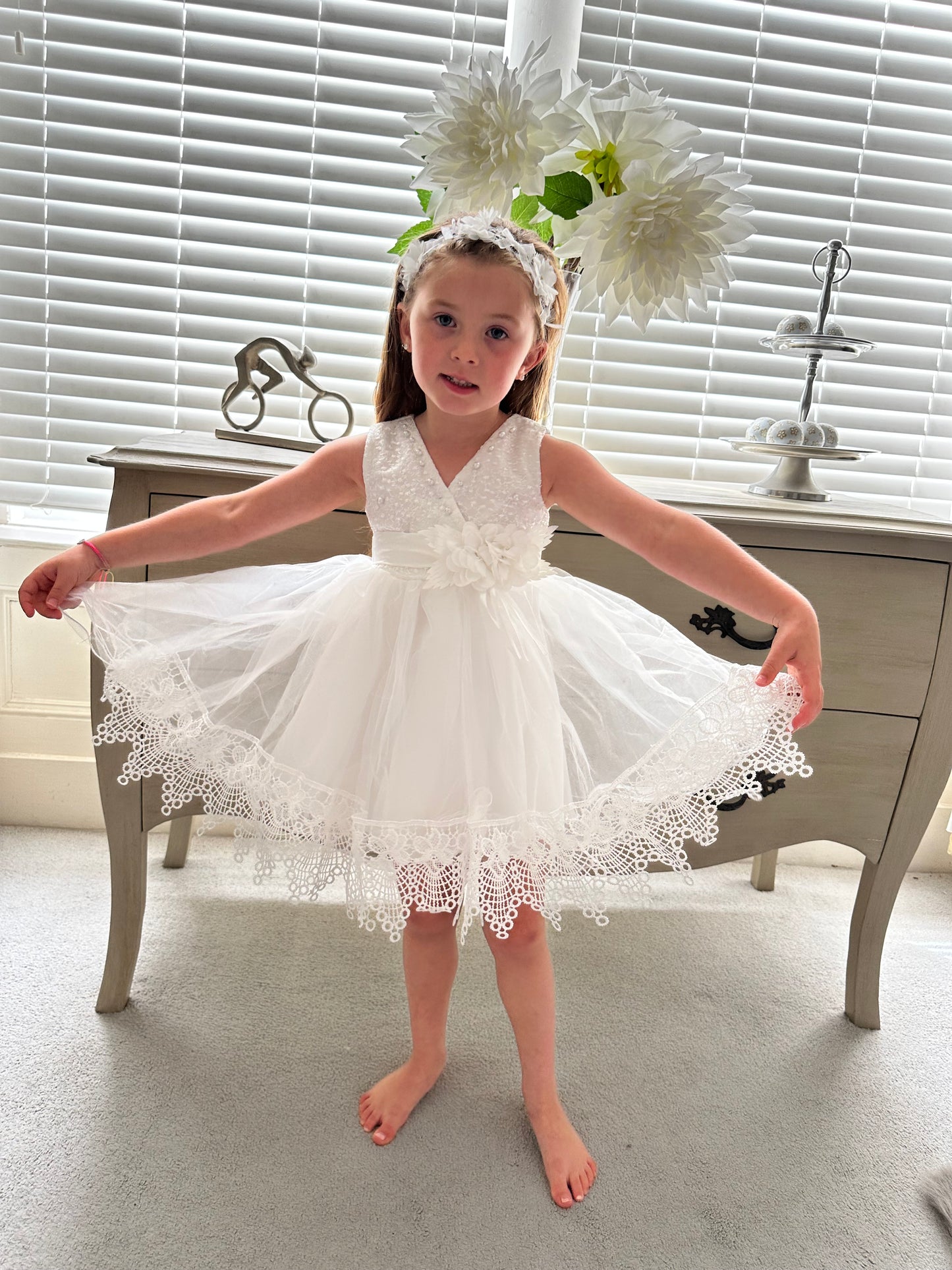 Detailed view of the full lace trimmed skirt on the ivory white special occasion baby dress by Little Babybox