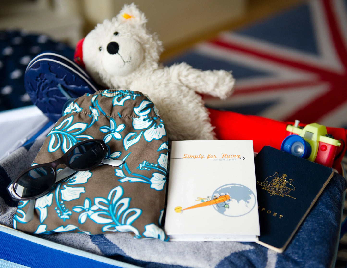 Childs suitcase packed with travel items and the Simply for Flying Logbook - Little Babybox