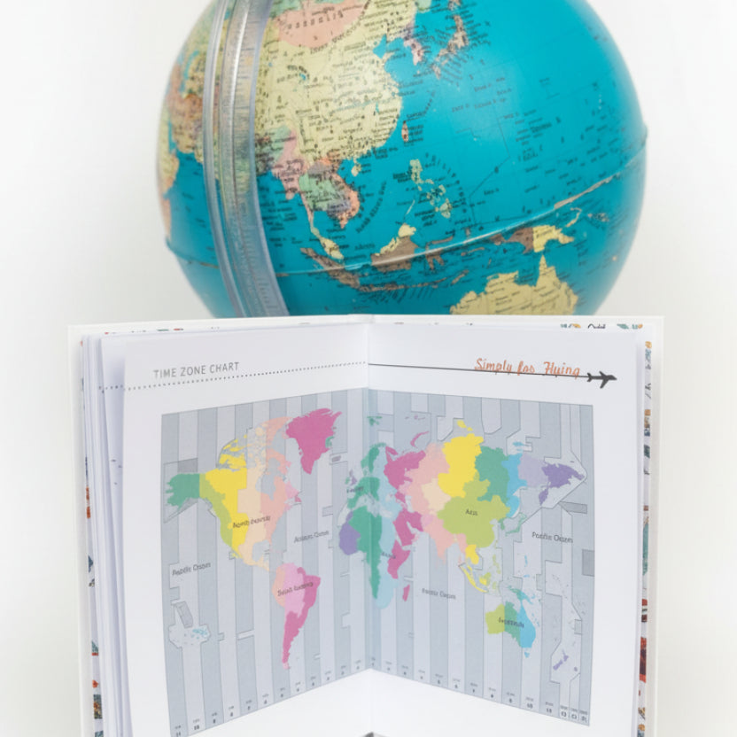 The Simply for Flying Logbook close up of one page open showing a multi-coloured world map and time zone chart with a blue globe in background - Little Babybox