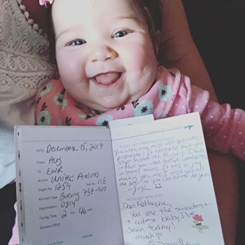 Baby holding her simply for flying logbook with pages completed by Captain and Crew - Little Babybox