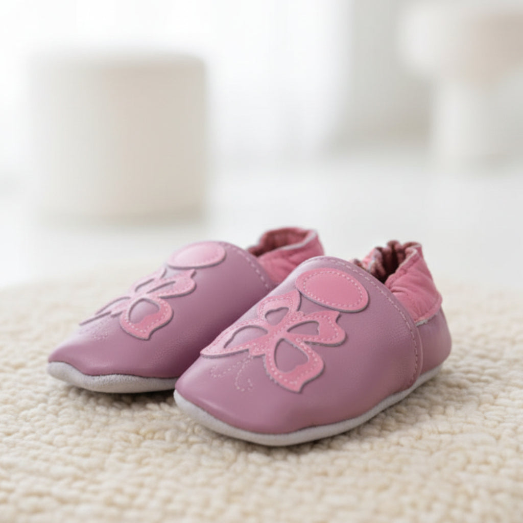 Side view of Miss Butterfly pre-walker baby shoes resting on a luxurious, thick cream boucle blanket - Little Babybox